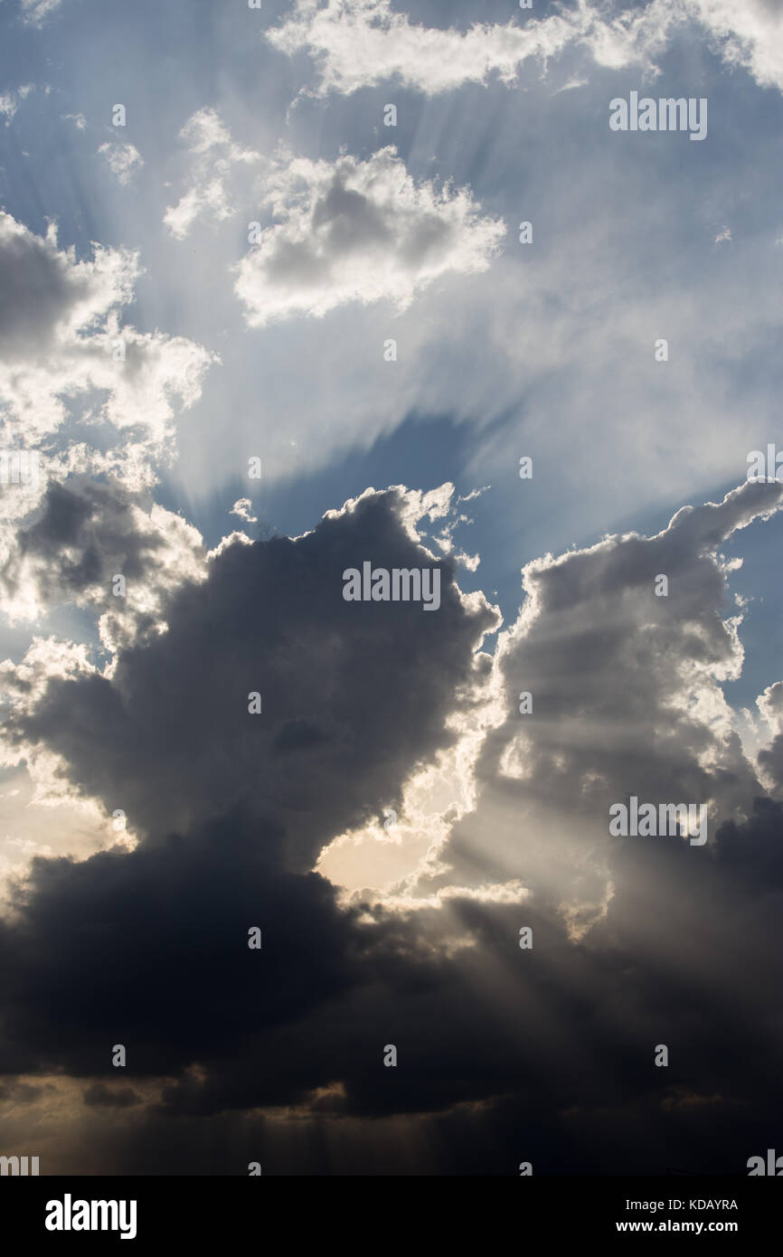 Powerful sun rays coming out through some clouds Stock Photo