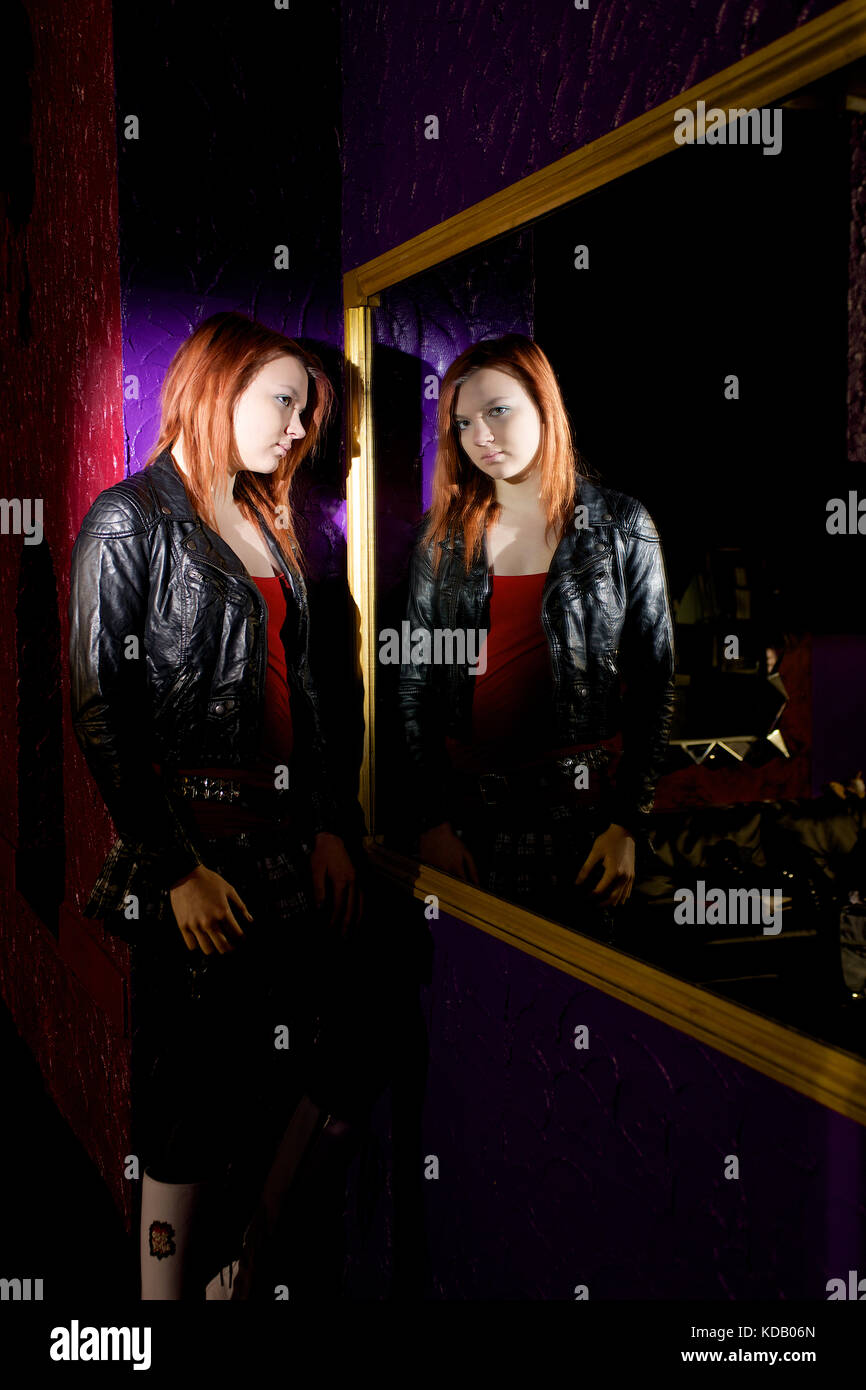 Pretty girl in a night club location wearing jacket and boots Stock Photo