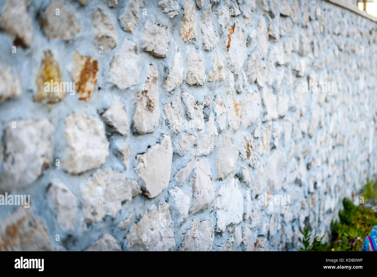 Stone rock fence or gabion and road or footpath. Old built rock wall ...