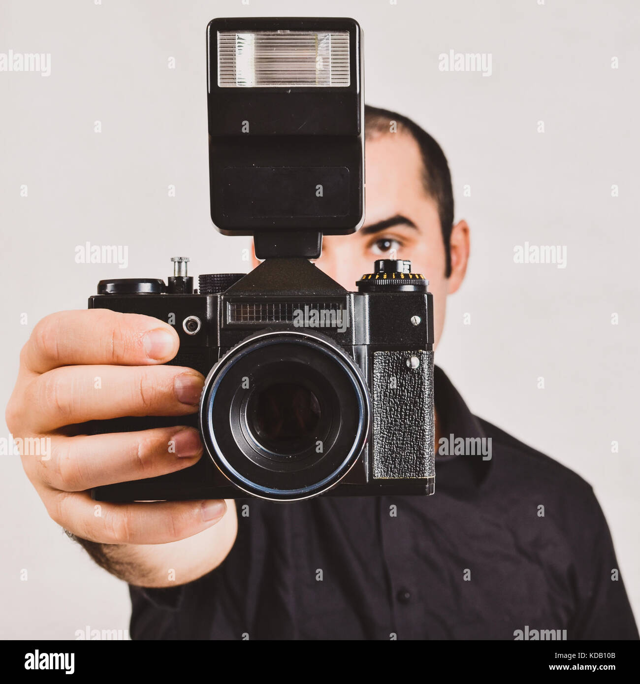 Professional photographer holding old, retro film camera and flash