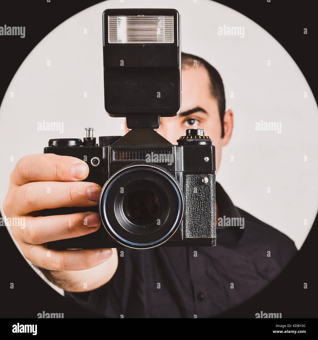 Professional photographer holding old, retro film camera and flash