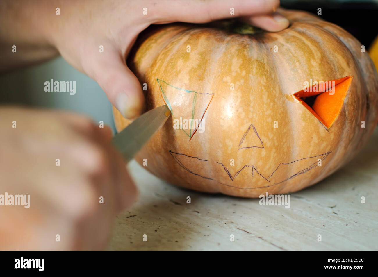 Halloween pumpkin cutting process, male hands with knife, seeds and ...