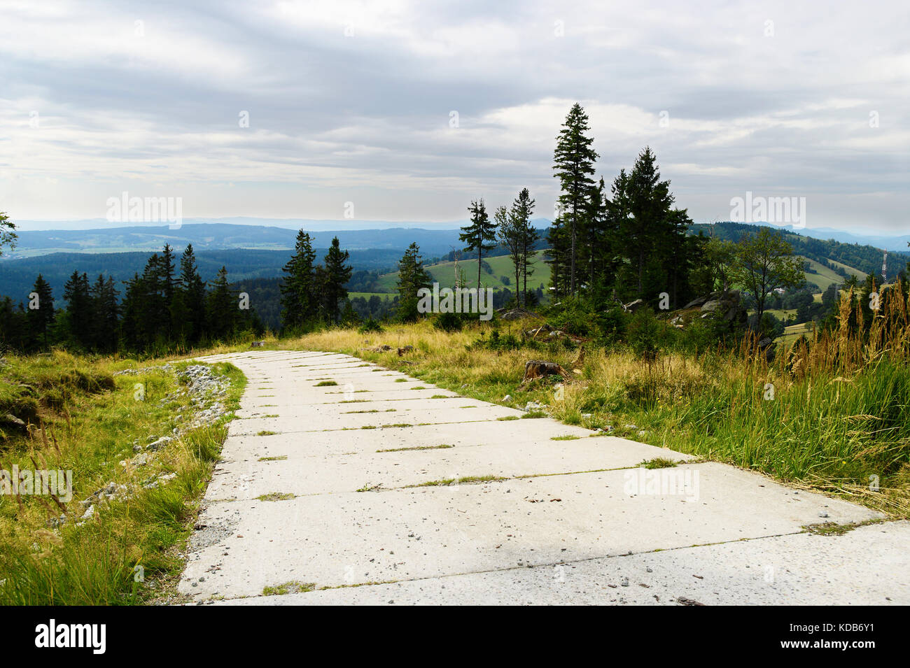 Road with concrete slabs pavement on hill in the Owl Mountains (Gory Sowie) Landscape Park, Sudetes, south-west Poland. Stock Photo