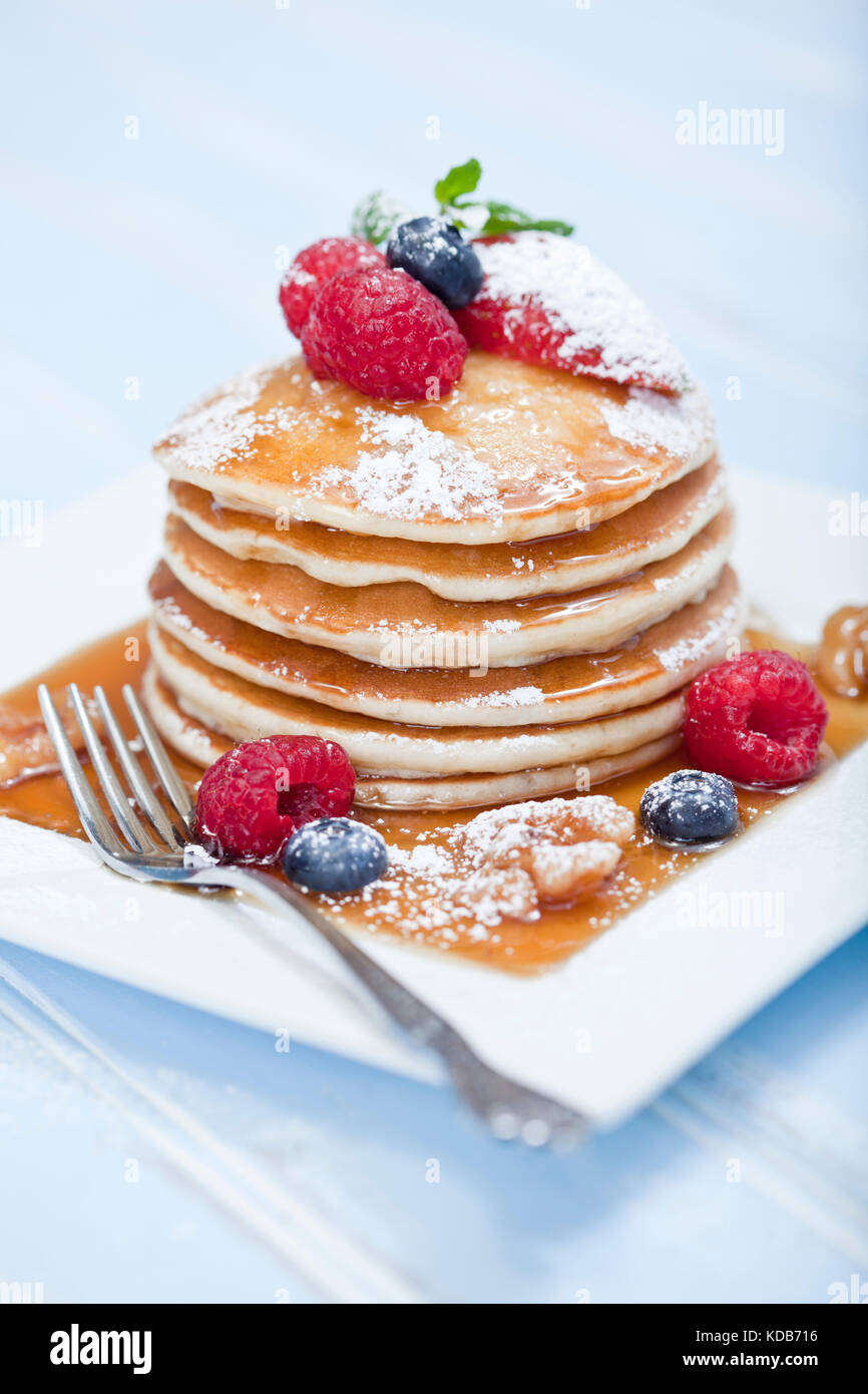 Stack of pancakes with mixed berries and maple syrup Stock Photo