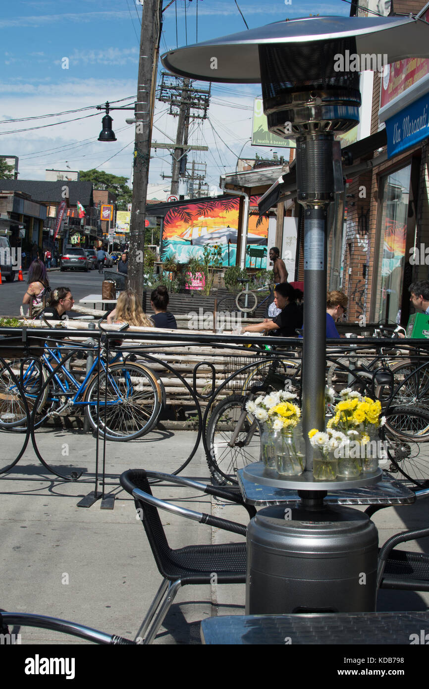 Kensington Place Toronto Canada  cycles and restaurant with heater and flowers bike pushbike plants plant flowers light heater chairs lamp place colour Stock Photo