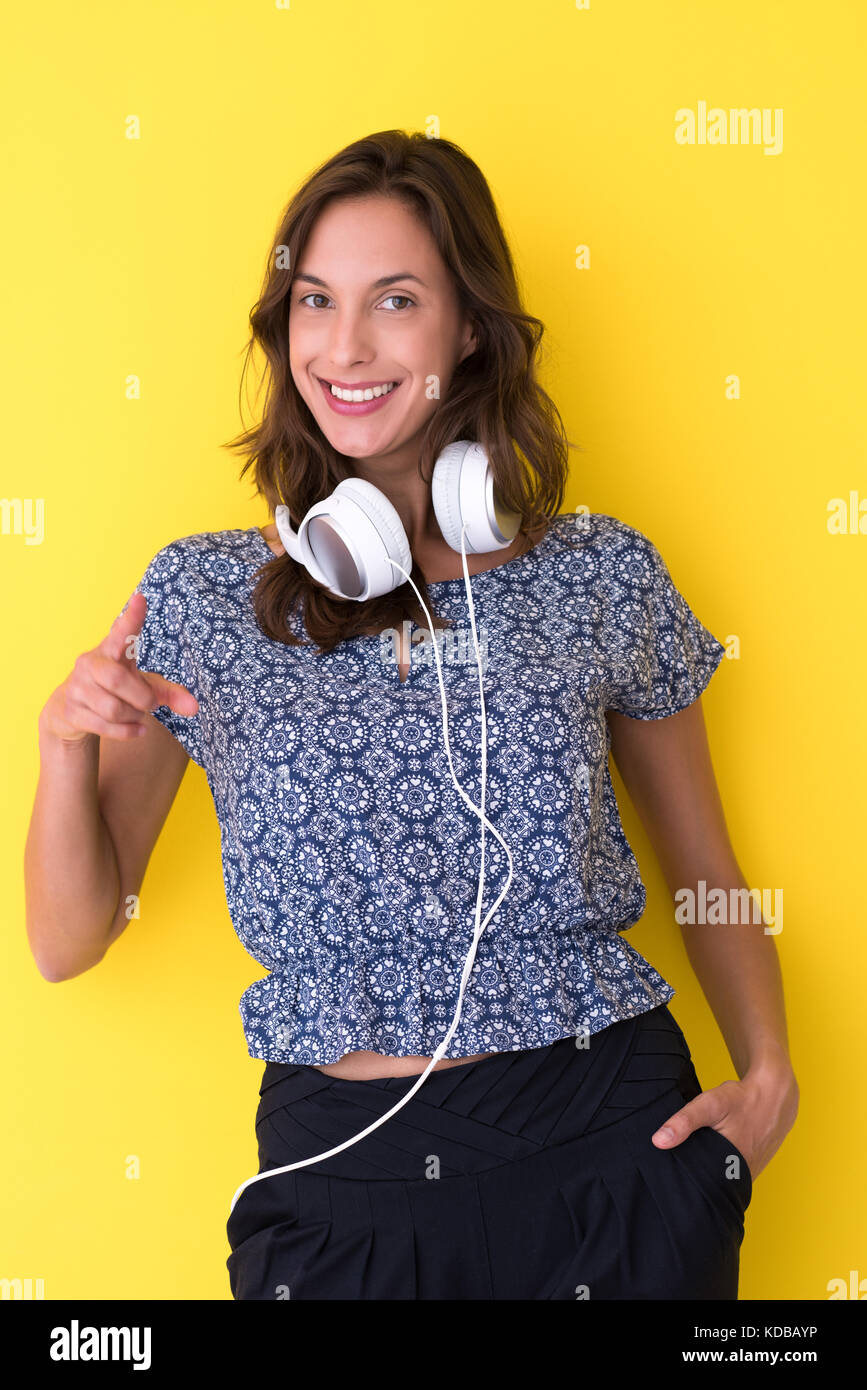 Happy young woman listening and enjoying music with headphones isolated ...