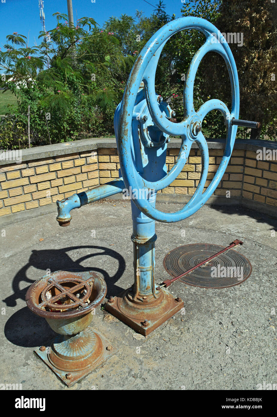 Blue water well pump, with wheel, on summer sun Stock Photo