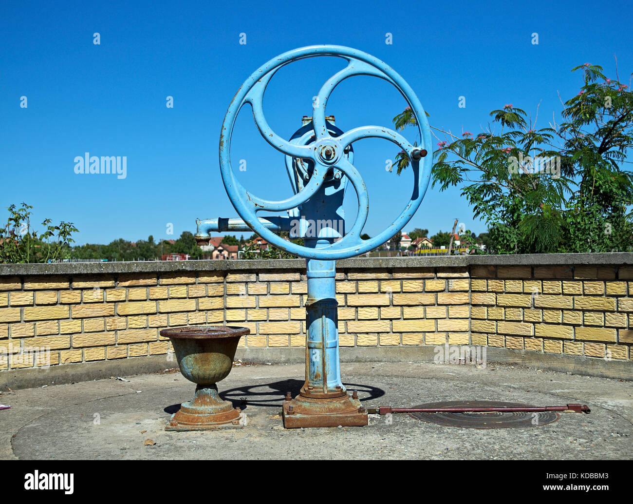 Blue water well pump, with wheel, on summer sun Stock Photo