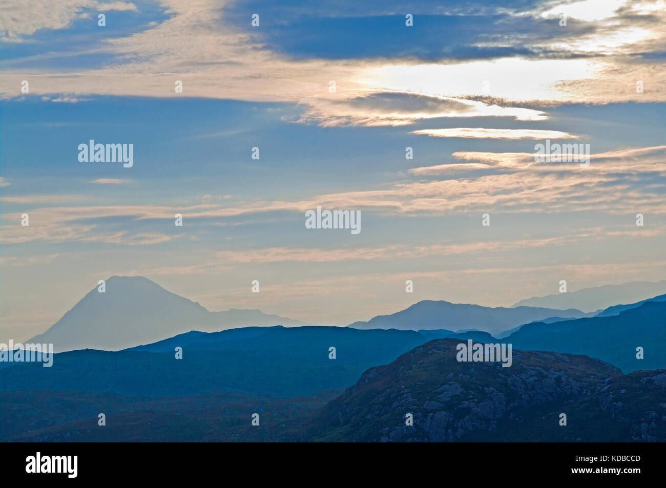 Atmospheric hazy dawn sky at Badcall, Sutherland, Northwest Highlands, Ben Stack rising on the left above rocky outcrops. Scotland UK Stock Photo