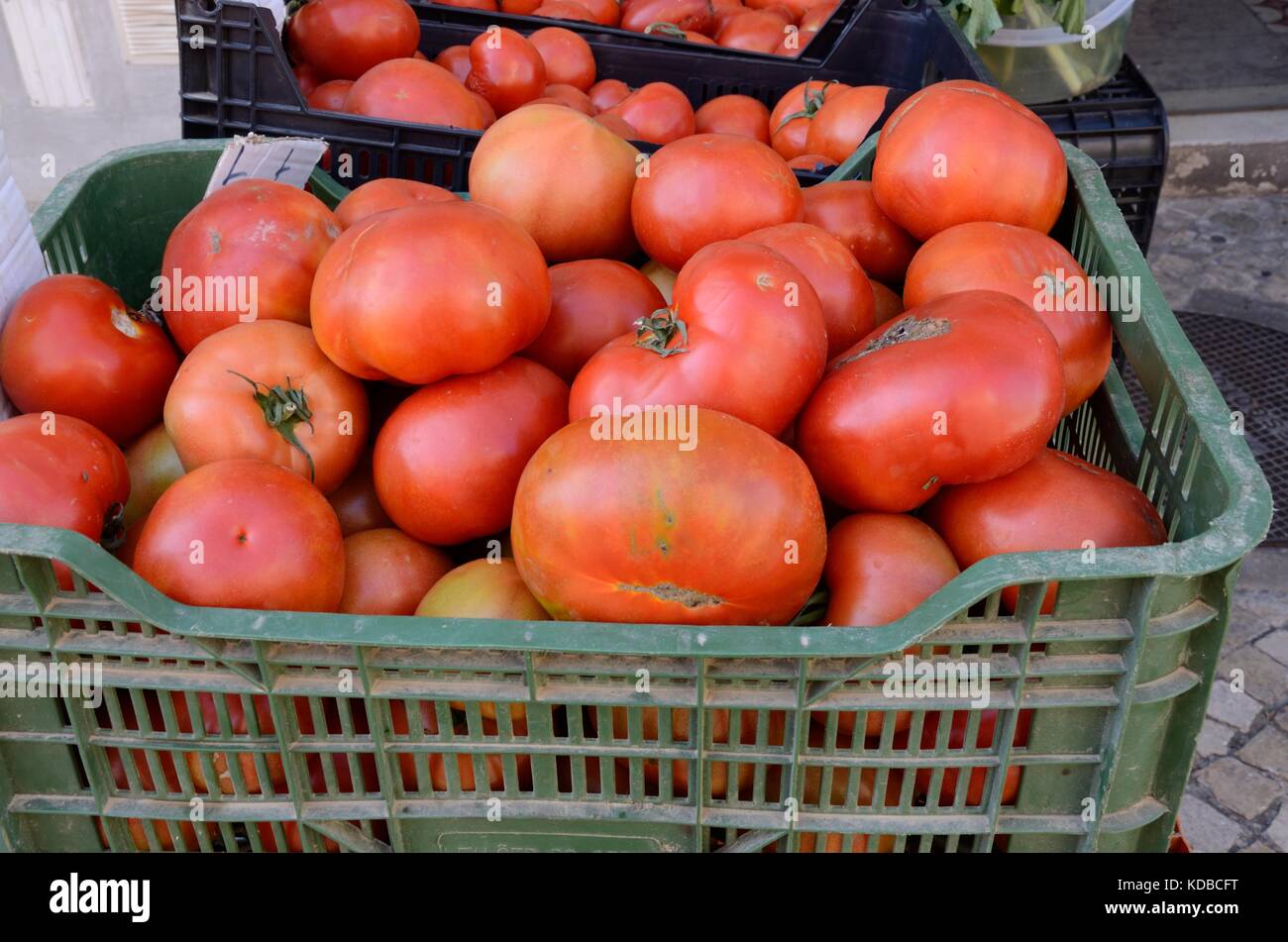 Crate of large organic misshapen tomatoes in a local market Portugal Stock Photo