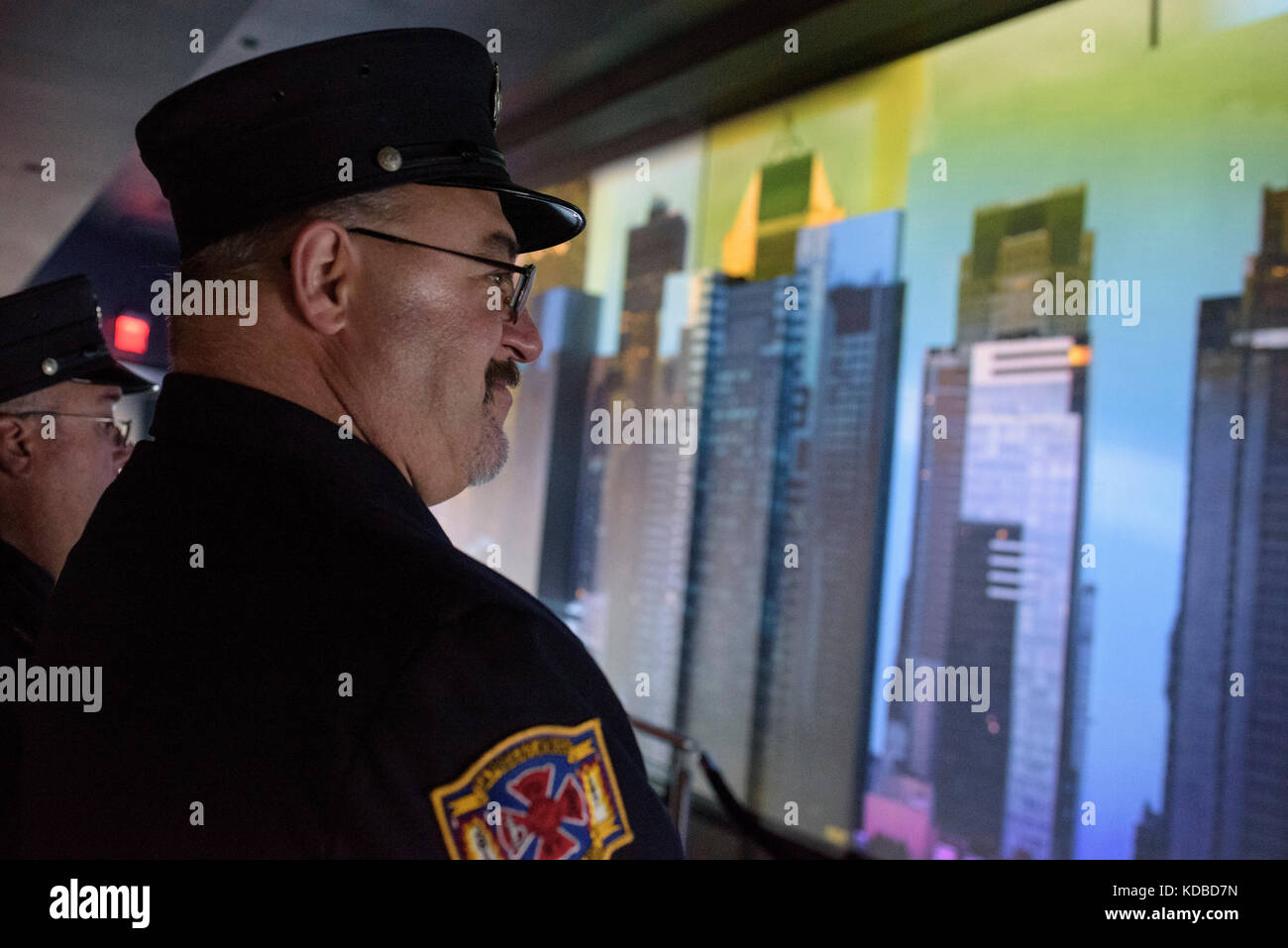 Un pompier de New-York observe un écran geant dans la nouvelle tour du world trade center à New York, le 11 septembre 2016. Stock Photo