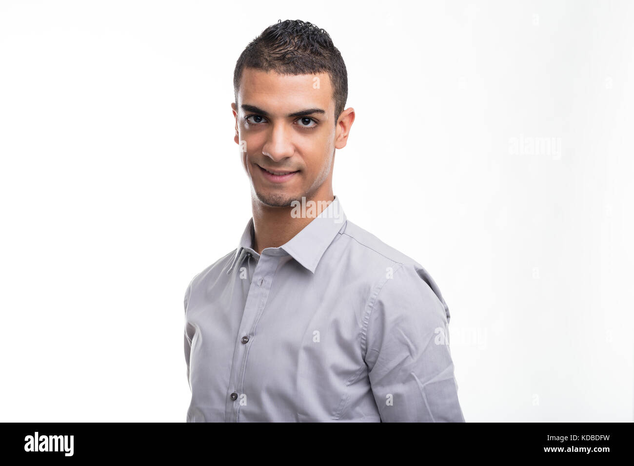 Portrait of young smiling man wearing shirt standing against white ...