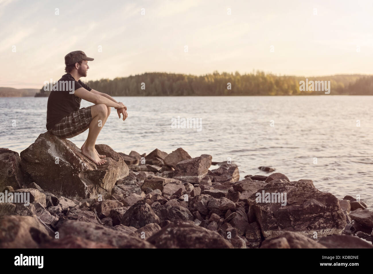 Young man overlooking a lake shortly after sunset Stock Photo