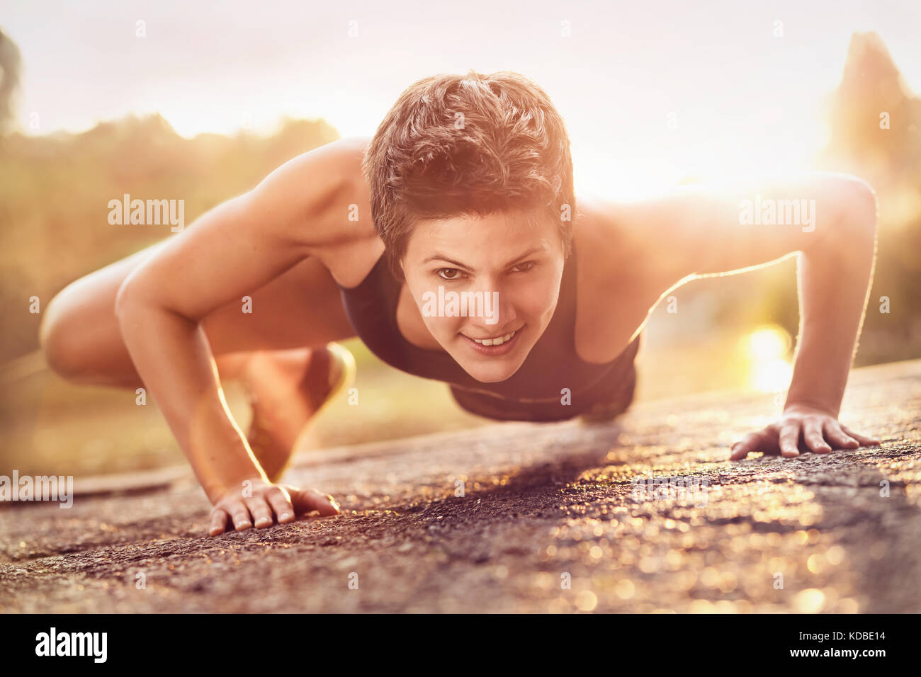 Woman with short hair doing push ups Stock Photo