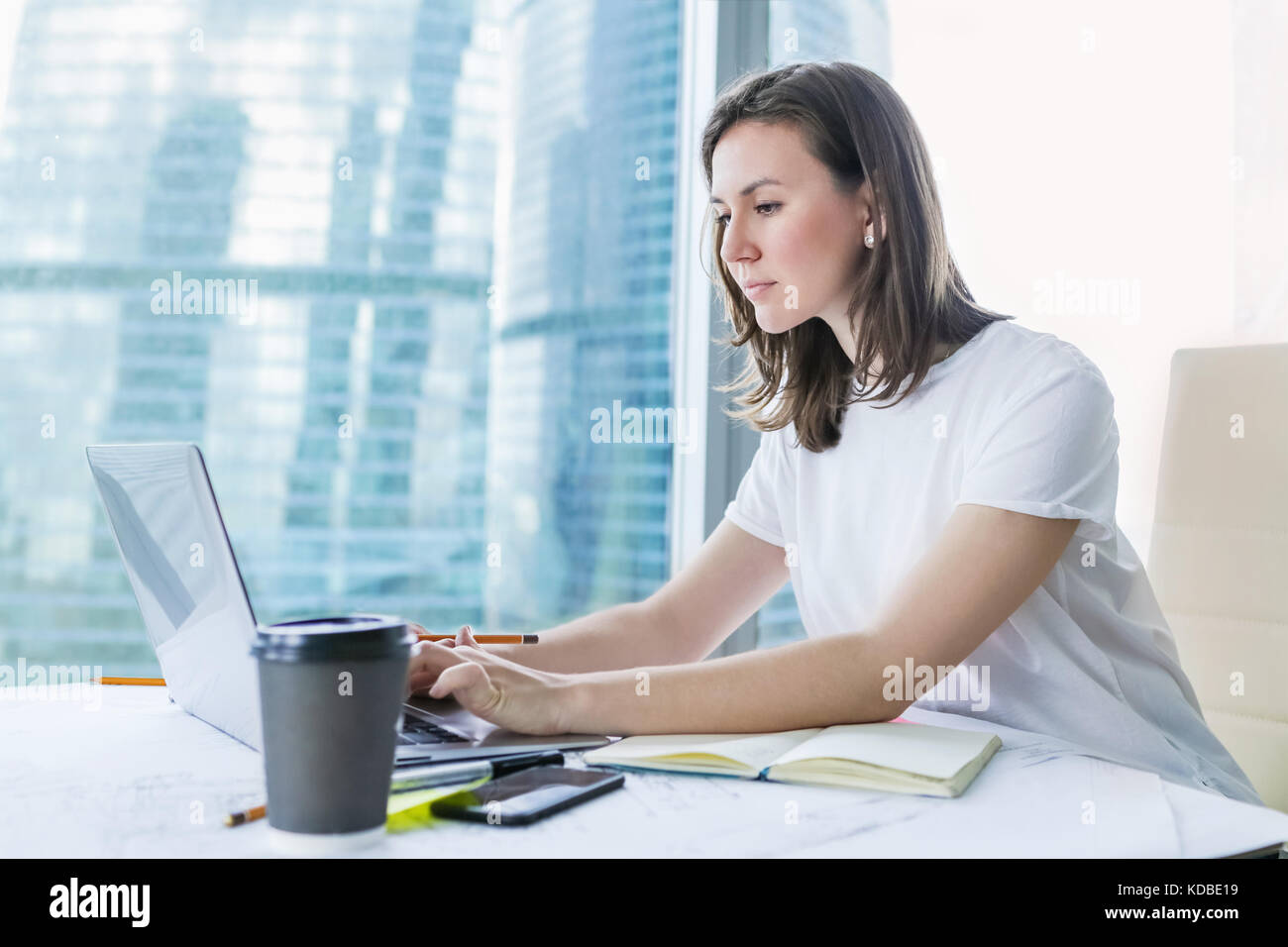 Young woman working on laptop at office Stock Photo