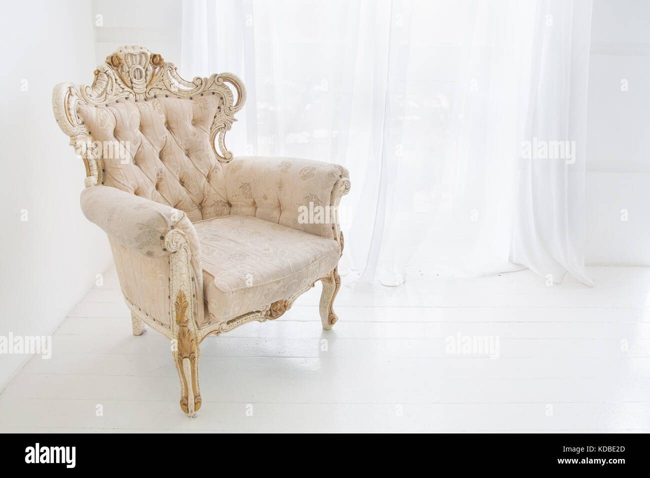 Vintage armchair in white room Stock Photo - Alamy
