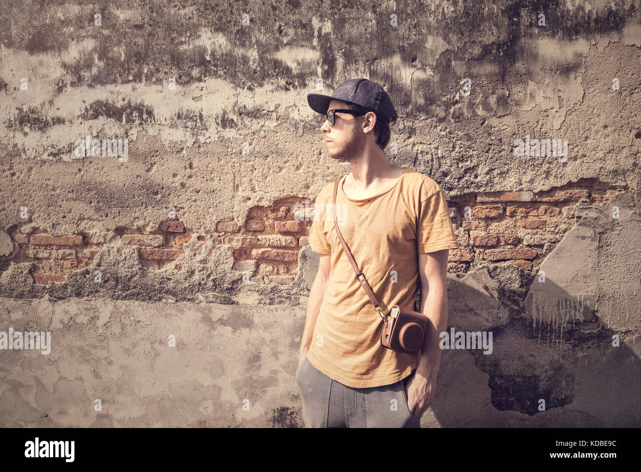 Young man in front of a decaying wall Stock Photo