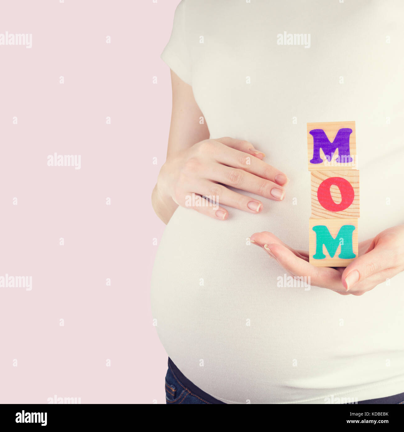 Pregnant woman holding MOM sign Stock Photo