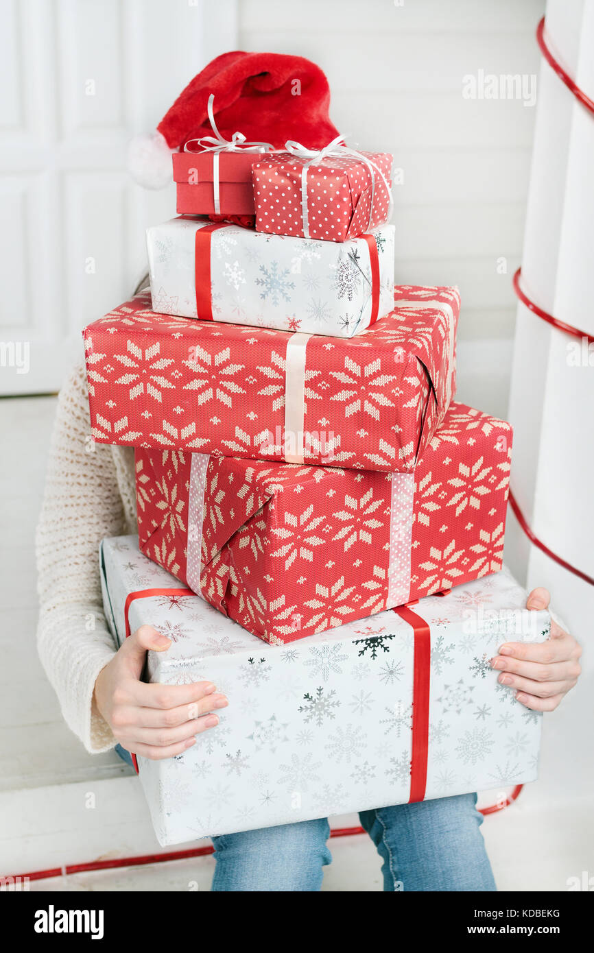 Woman hiding face behind pile of gifts Stock Photo