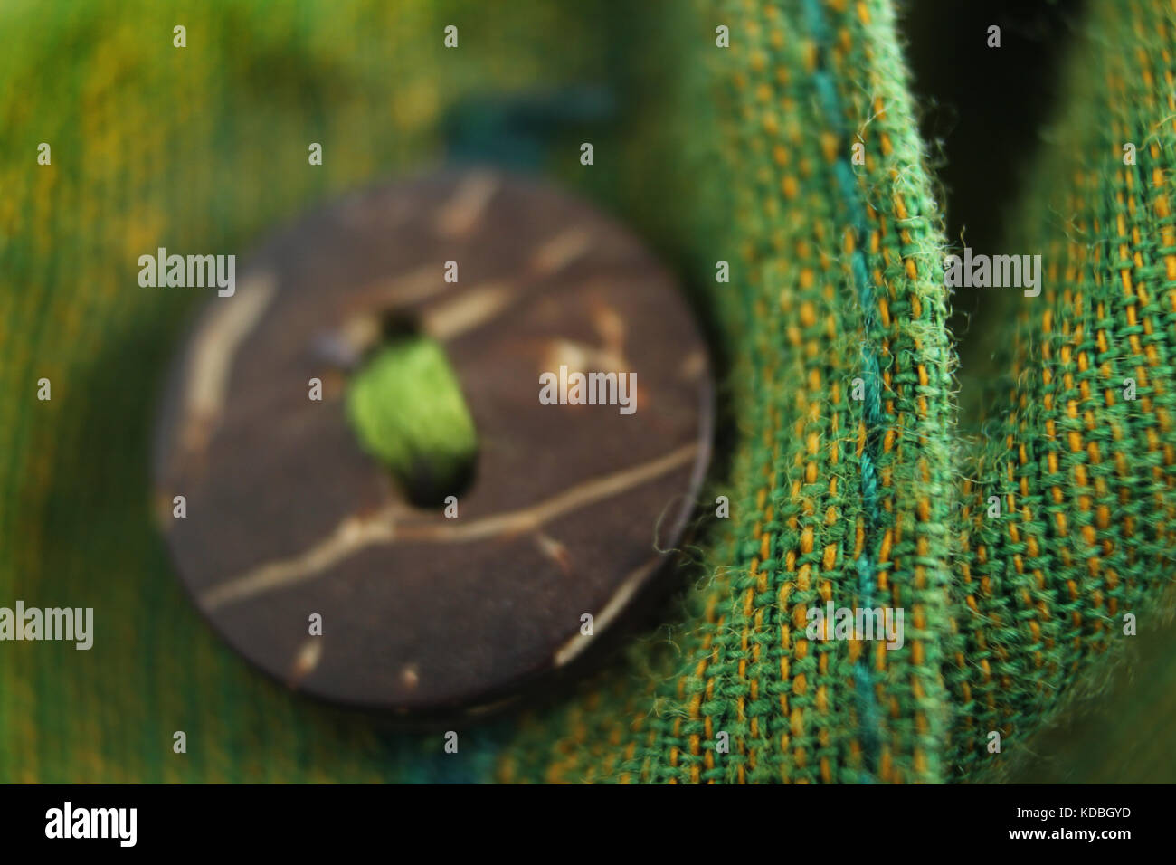 Close-up of button on green cotton fabric Stock Photo