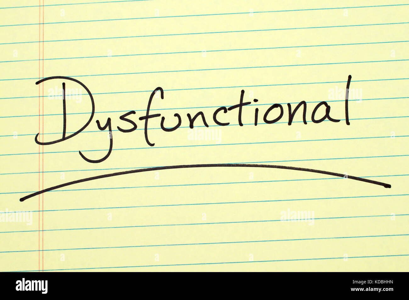 The word "Dysfunctional" underlined on a yellow legal pad Stock Photo