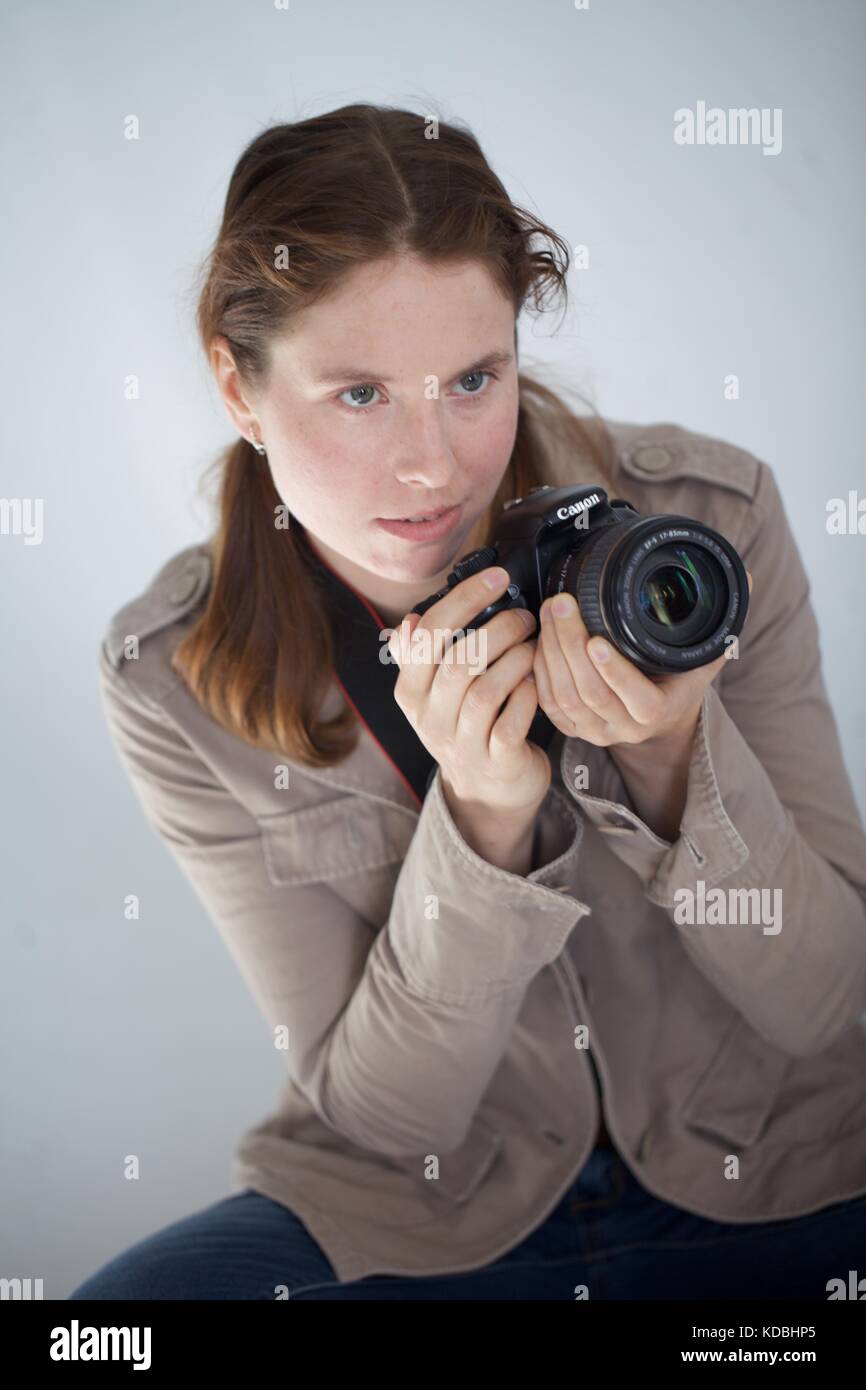 Woman sits DSLR camera Stock Photo