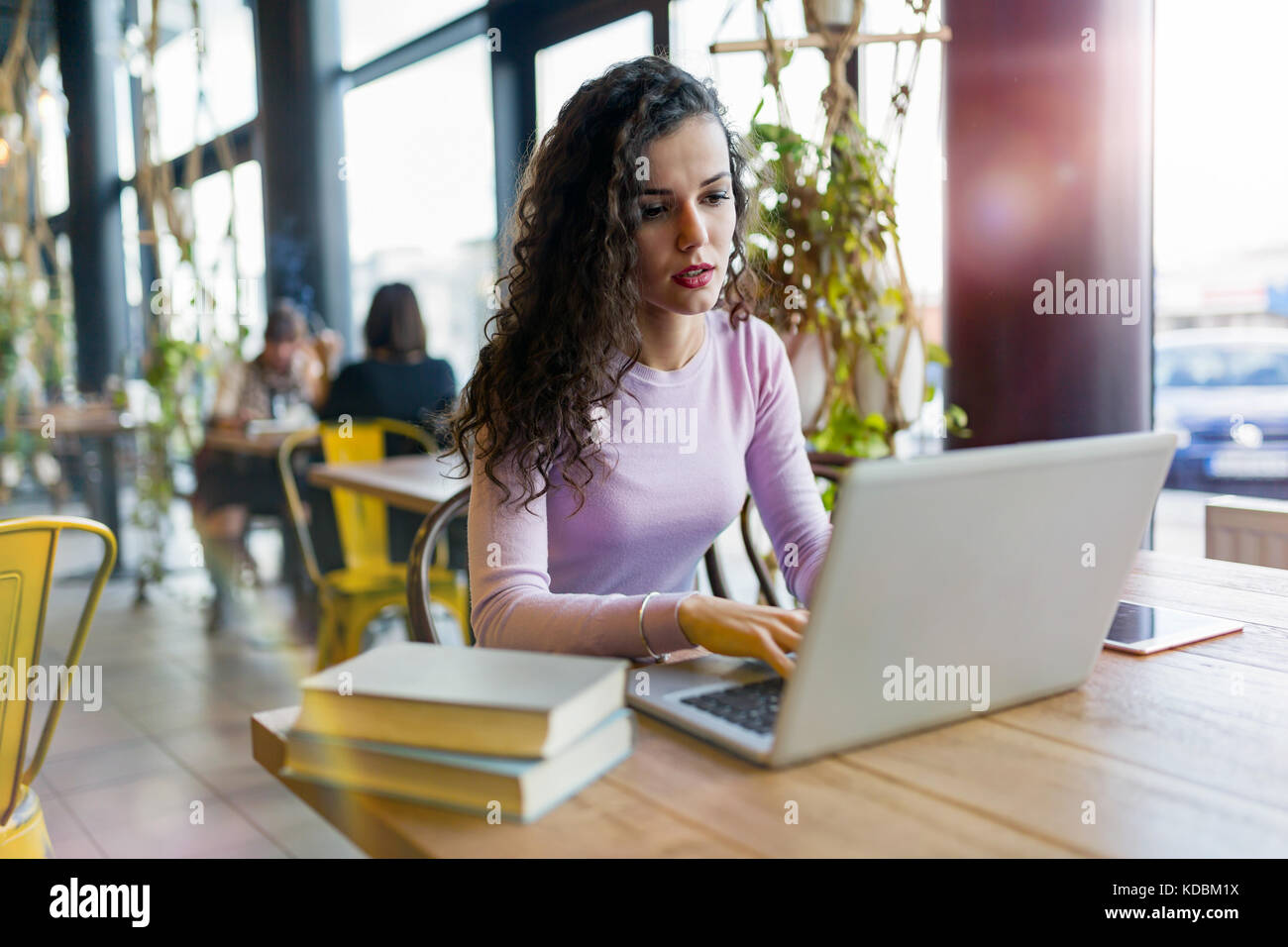 Young woman working on laptop in coffee shop Stock Photo - Alamy