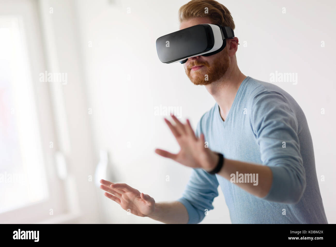 Man wearing virtual reality headset at home Stock Photo - Alamy