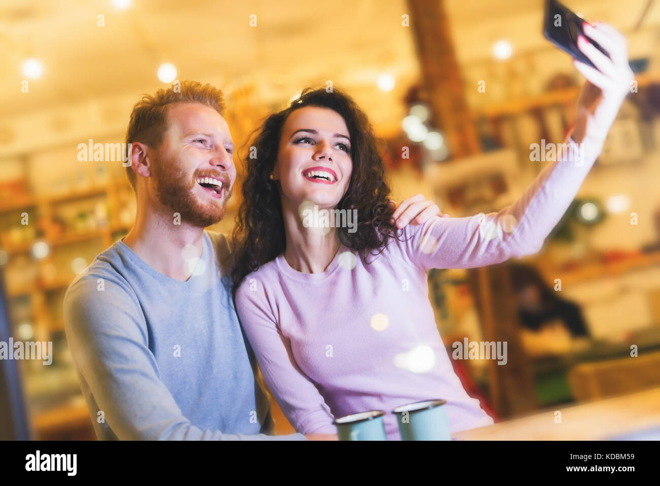Happy couple taking selfie in coffee shop Stock Photo