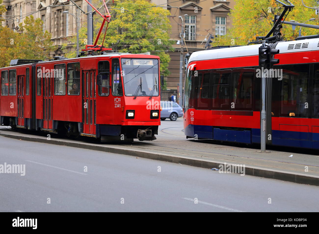 Old Red Tatra KT4 tram and new CAF Urbos 3 tram on the streets of Belgrade, Serbia Stock Photo