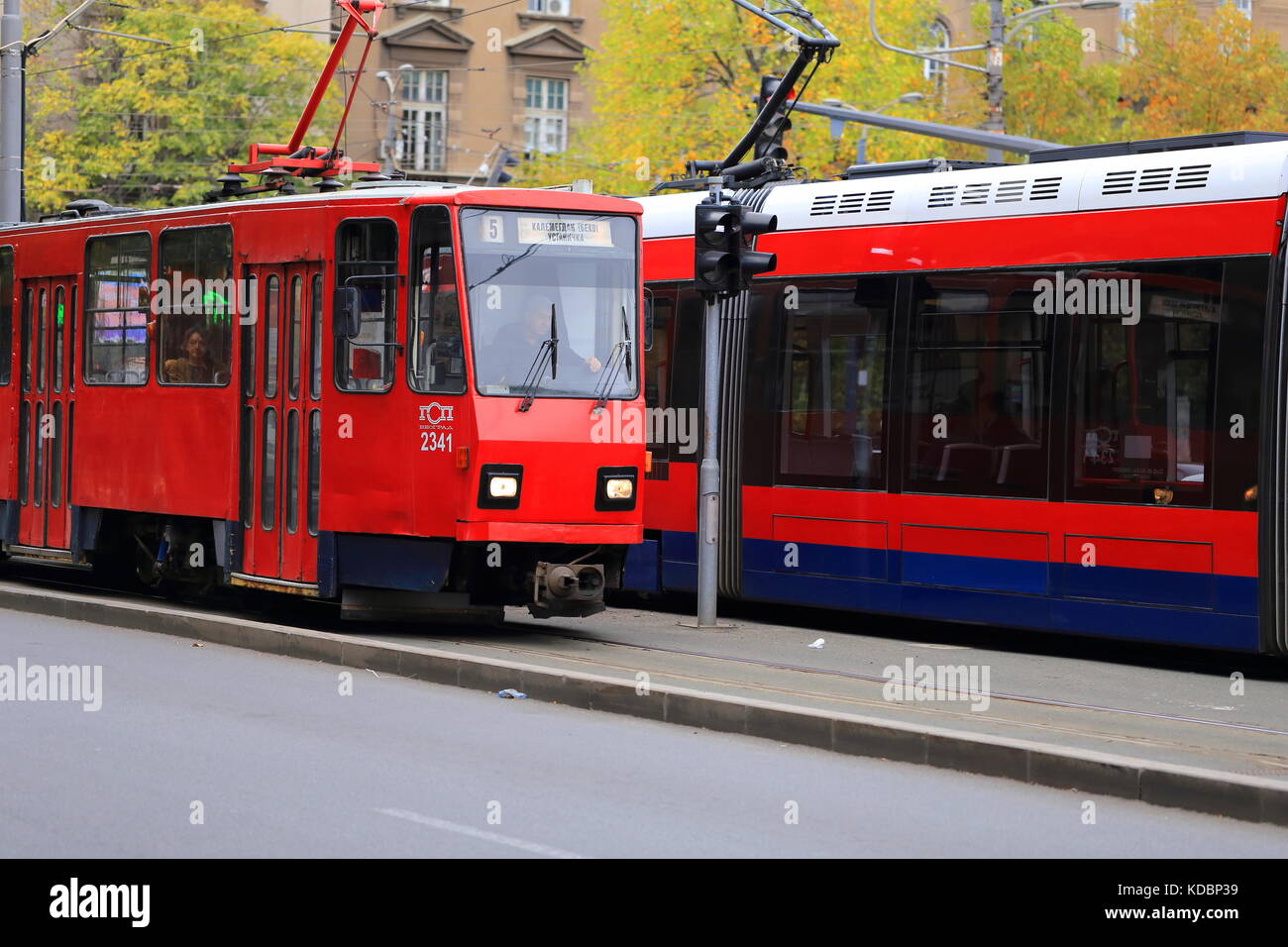 Old Red Tatra KT4 tram and new CAF Urbos 3 tram on the streets of Belgrade, Serbia Stock Photo