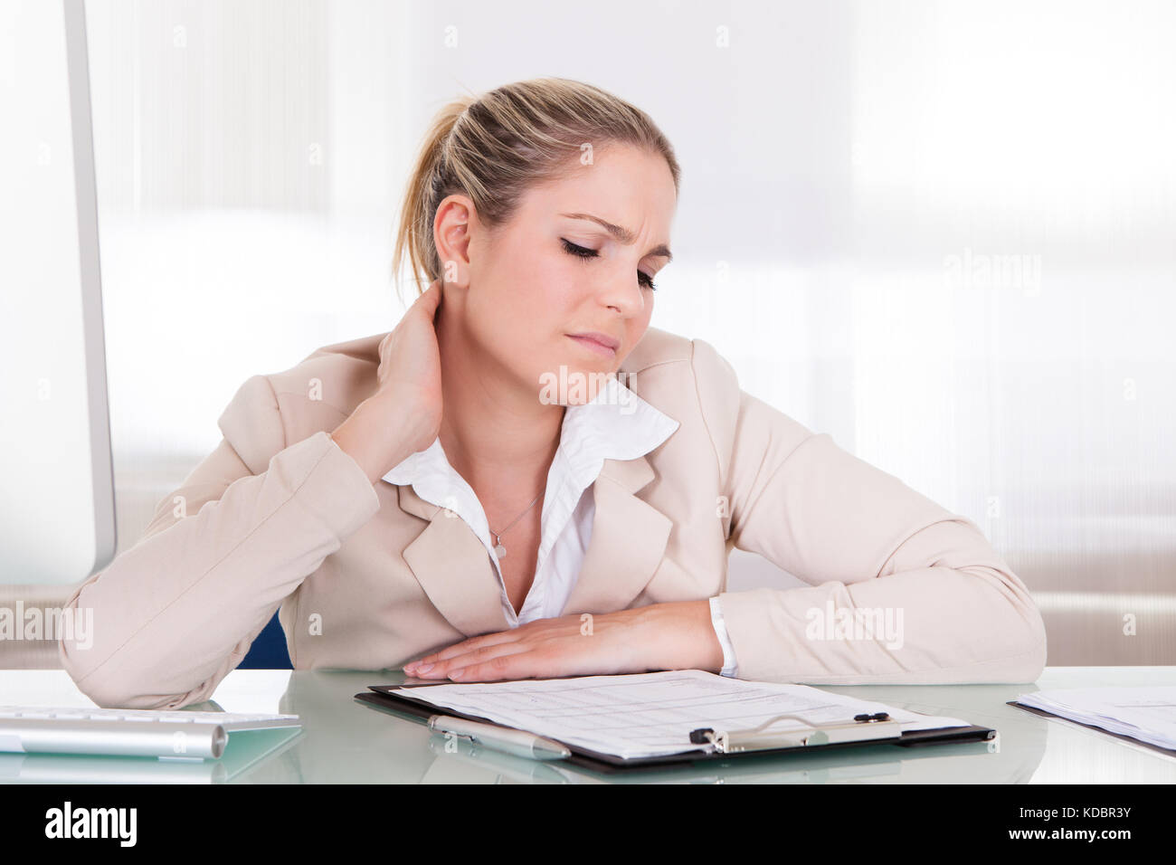 Young Businesswoman Suffering From Neck Pain At Office Stock Photo - Alamy