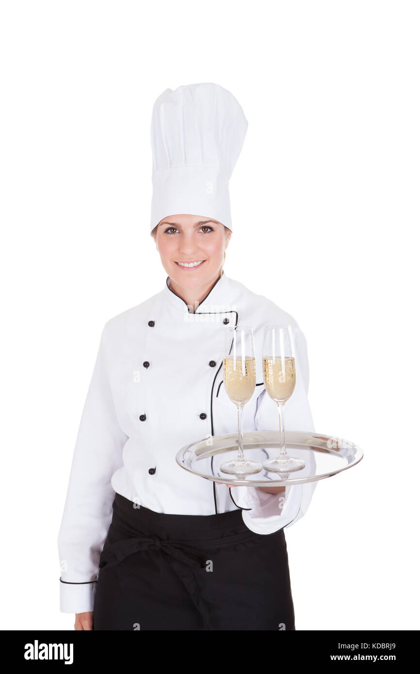 Portrait Of Female Chef Holding Champagne Over White Background Stock Photo