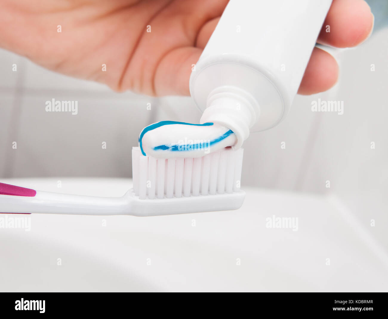 Close up of Hand holding a tooth brush with paste Stock Photo