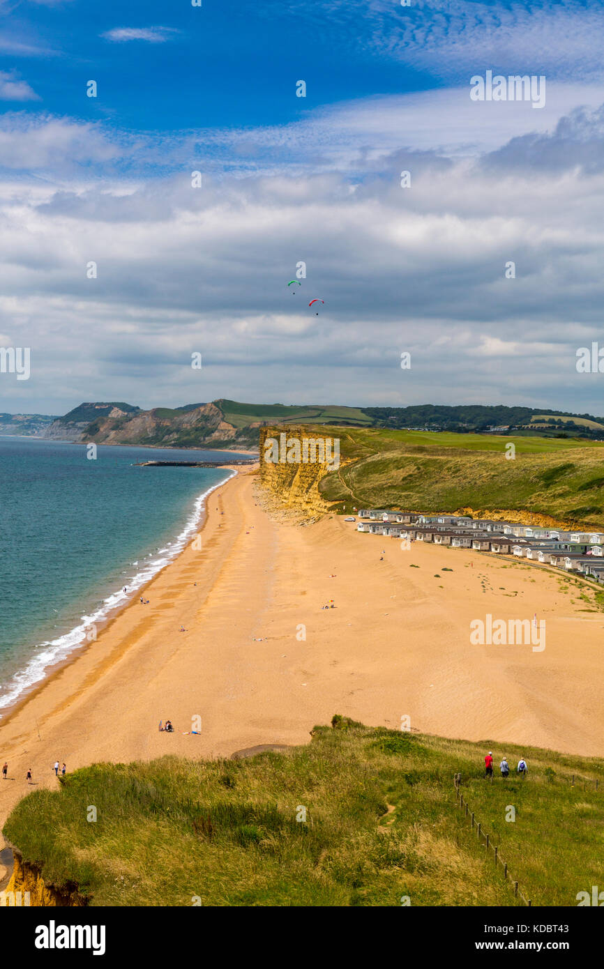 A group of walkers on the South West Coast Path at Burton Bradstock sandstone cliffs on the Jurassic Coast, Dorset, England, UK Stock Photo