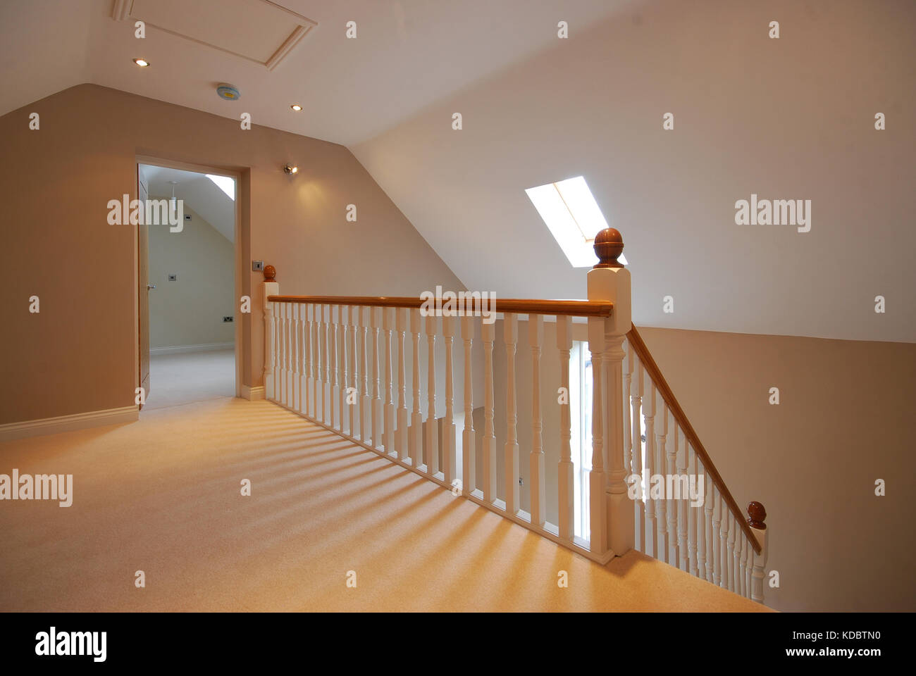 Landing and wooden stairs with white wooden spindles and banister Stock Photo