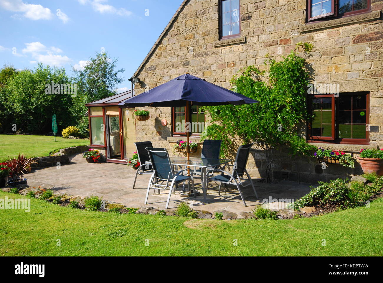English cottage patio with furniture and parasol umbrella in sunshine