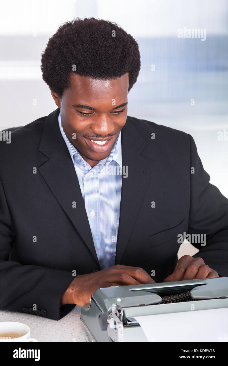 Portrait Of Happy Business Man Typing On Typewriter Stock Photo