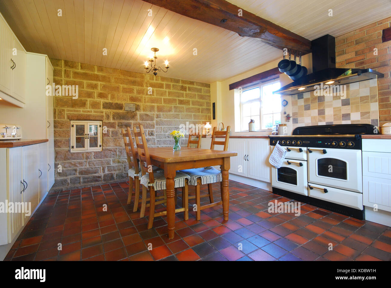 Farm kitchen with terracotta tiled floor and exposed stone work Stock Photo