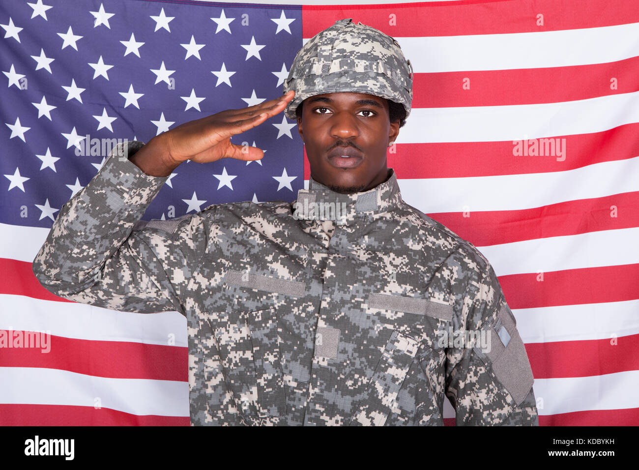Portrait Of Afro-american Army Soldier Saluting In Front Of American Flag Stock Photo