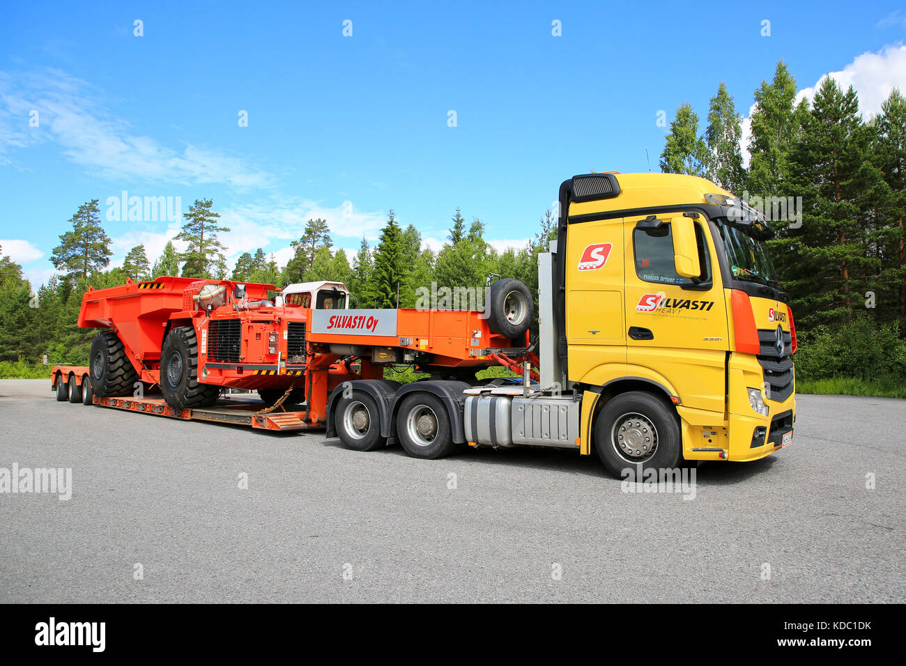 LEMPAALA, FINLAND - JULY 6, 2017: Mercedes-Benz Actros 3351 of Silvasti Heavy hauls Sandvik TH550 Underground Truck on gooseneck trailer across asphal Stock Photo
