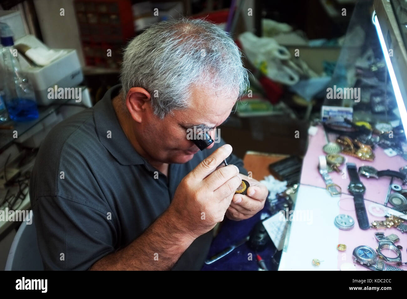 Edremit, Turkey - August 21, 2017: Traditional watchmaker repairs a watch with magnifier in Edremit, Turkey. Stock Photo