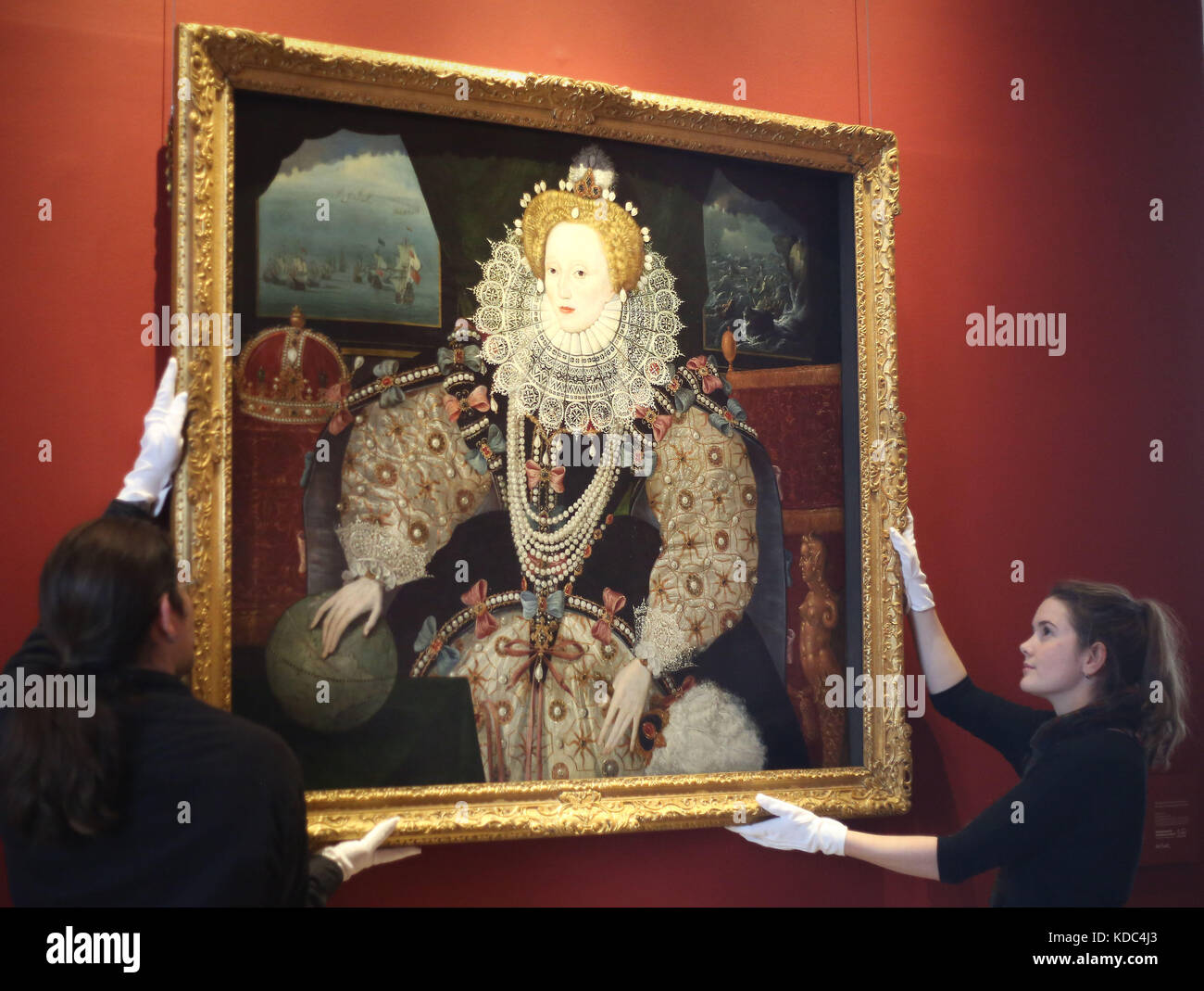 Art handlers reinstall the Armada Portrait of Elizabeth I in the Queen’s House, Royal Museums Greenwich, London, following conservation work. Stock Photo