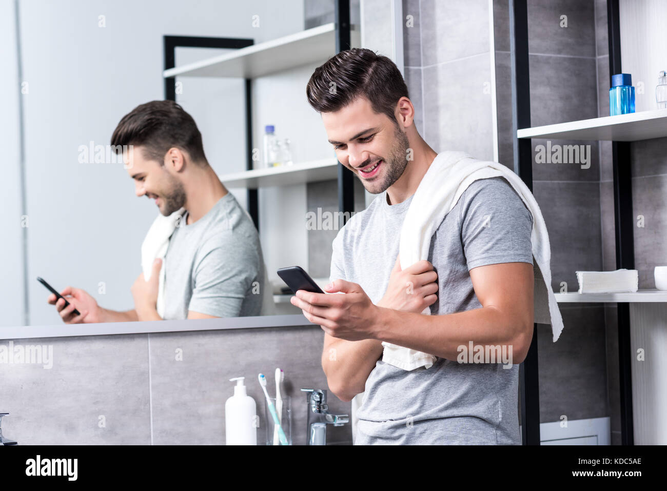 man using smartphone in bathroom Stock Photo Alamy
