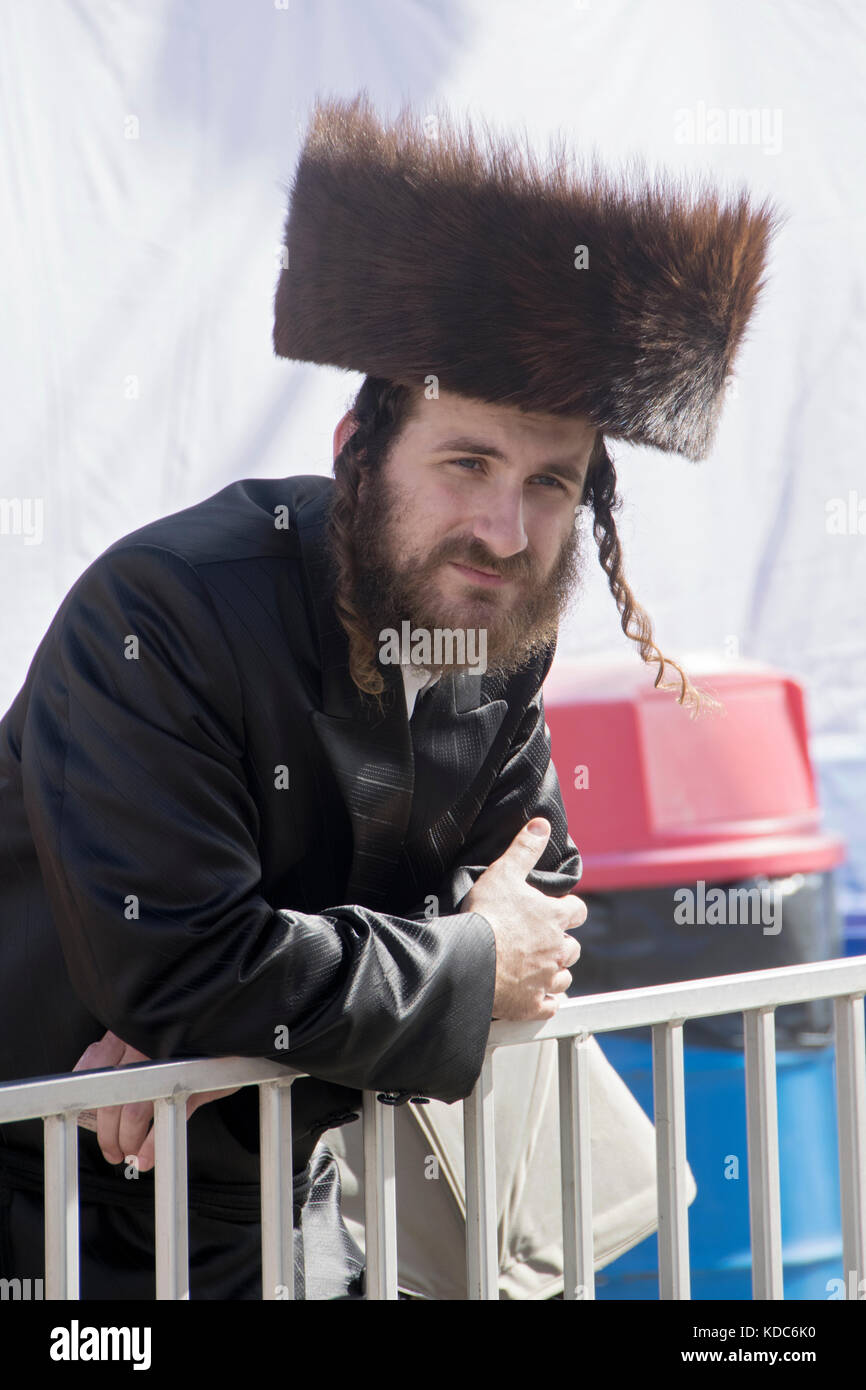 A hasidic Jewish man wearing a shtreimel fur hat out with his family at an amusement park in Brooklyn, New York. Stock Photo