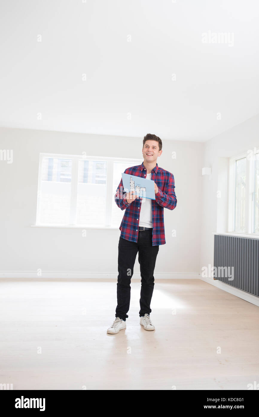 Man Looking At Brochure With Details For New Home Stock Photo