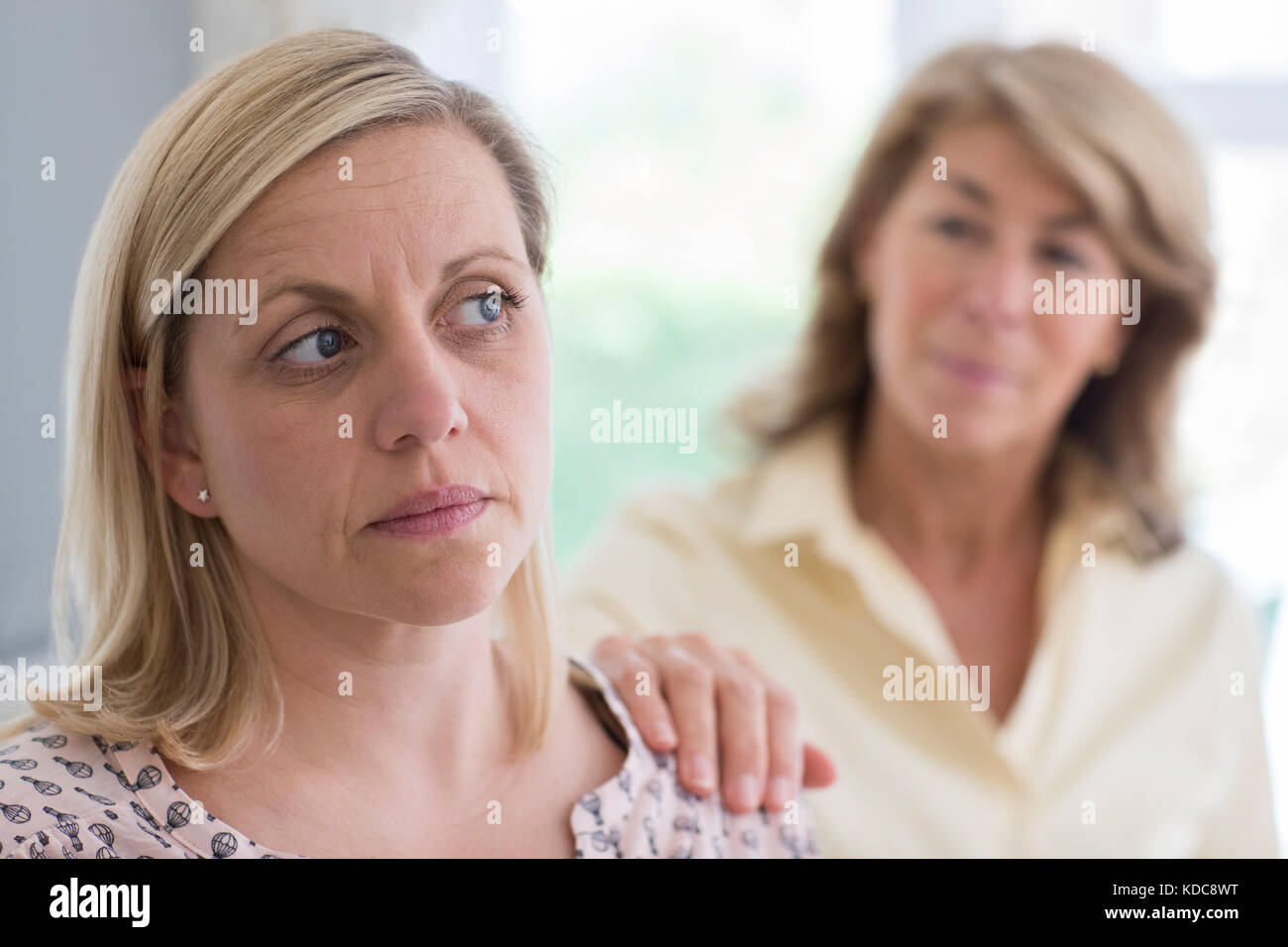 Mature Mother Concerned About Adult Daughter At Home Stock Photo