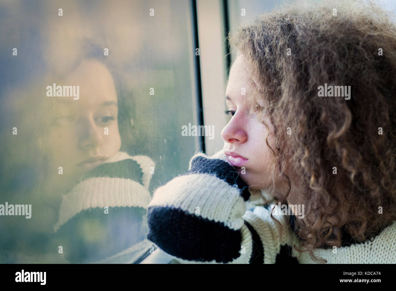 Portrait of the serious teenage girl sitting by the window Stock Photo