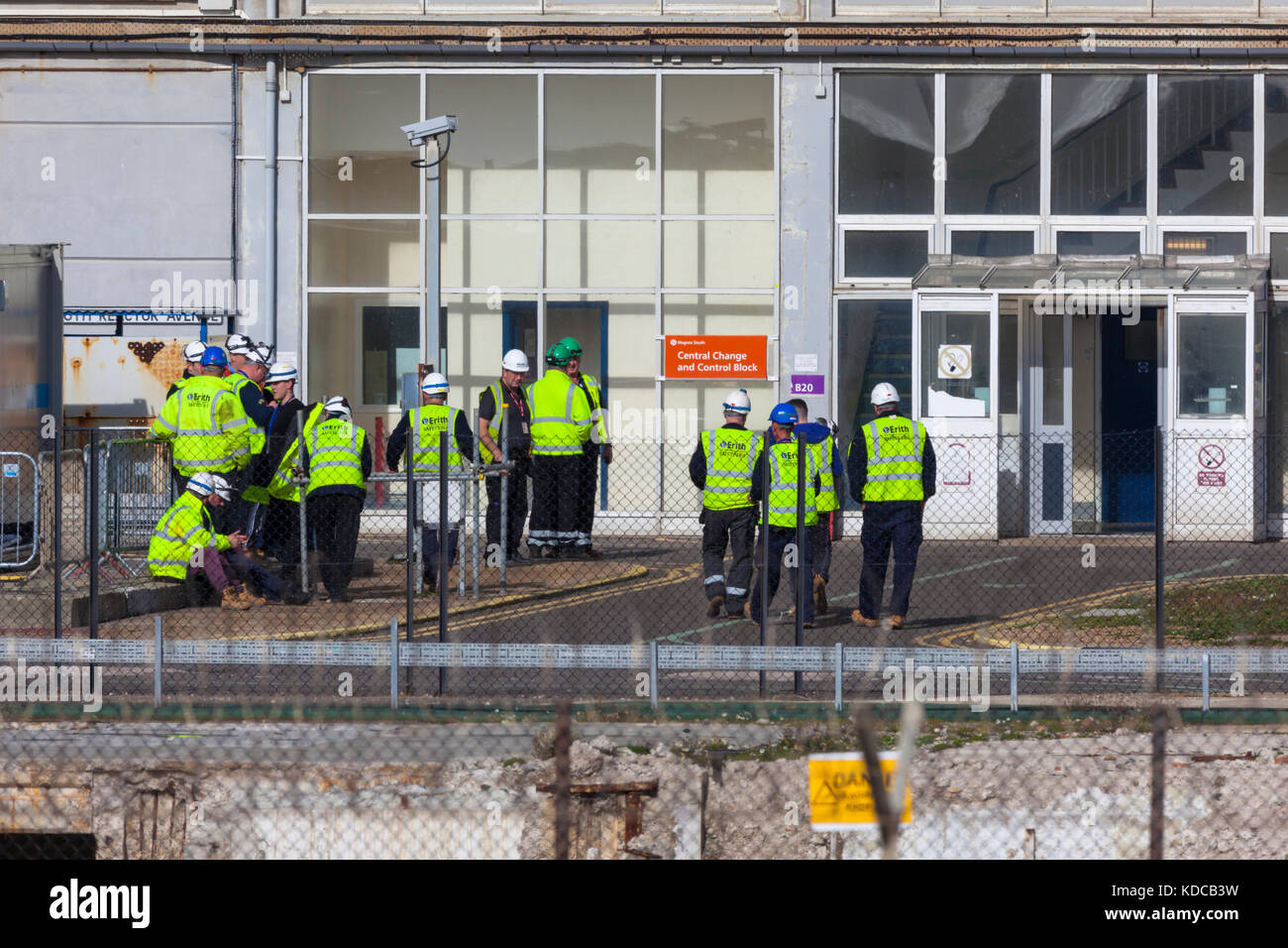 Workmen in reflective vests seen outside the dungeness nuclear power plant Stock Photo