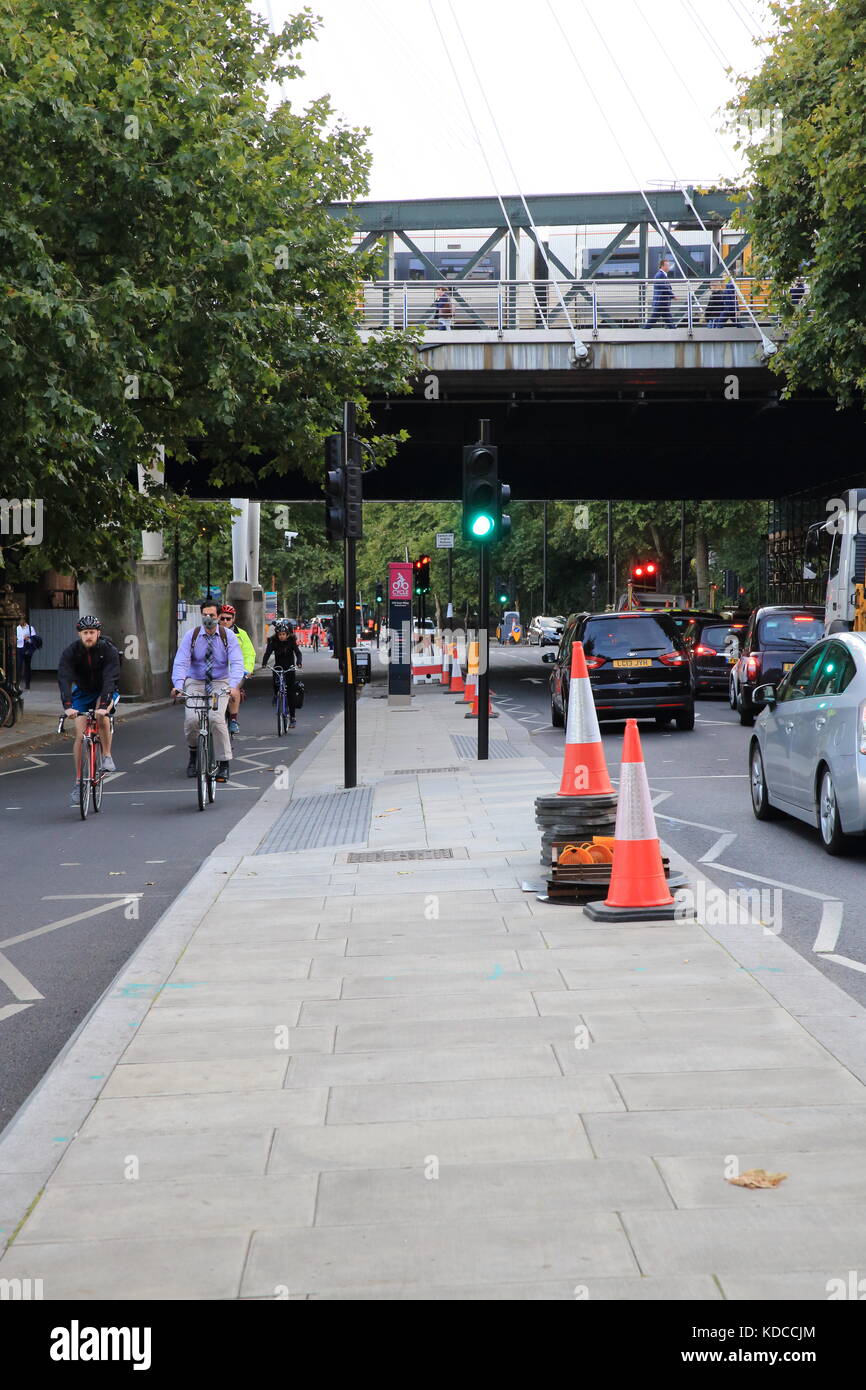 Cyclists in a segregated lane, and traffic on the Embankment in London, England, UK Stock Photo
